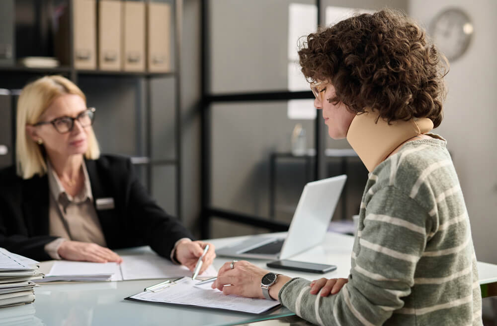 An injured woman goes over paperwork with her lawyer.